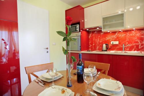una cocina con una mesa de madera con un jarrón con una rosa en Zadar Old Town Apartments II, en Zadar