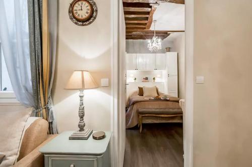 een slaapkamer met een bed en een klok aan de muur bij Le Jardin Du Marais in Parijs