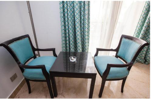 two chairs and a glass table with a table and a table and chairs at Blend Elphistone Resort Marsa Alam in Abu Dabab