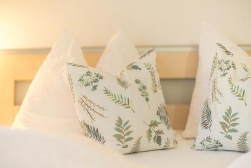 a bed with three pillows on a bed with at Residence Ortlerhof in Prato allo Stelvio