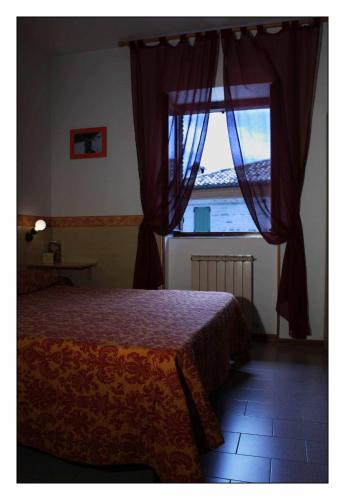 a bedroom with a bed and a large window at Due Torri in San Severino Marche
