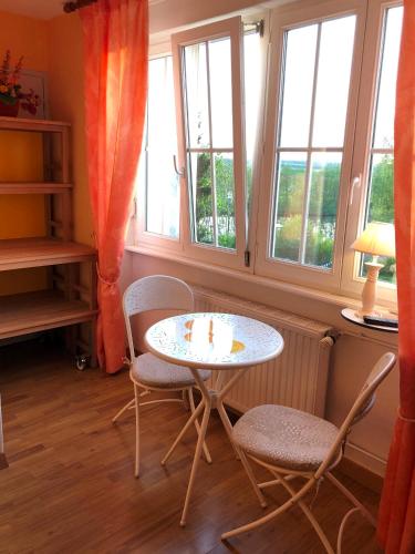a table and chairs in a room with windows at Domaine du Port Sainte Marie in Maizières-lès-Vic