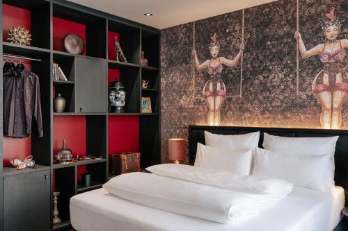 a bedroom with a bed with two posters of women on the wall at Aiola Living Graz in Graz