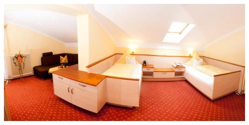 a hospital room with two beds and a couch at Aparthotel Grabner in Bad Füssing