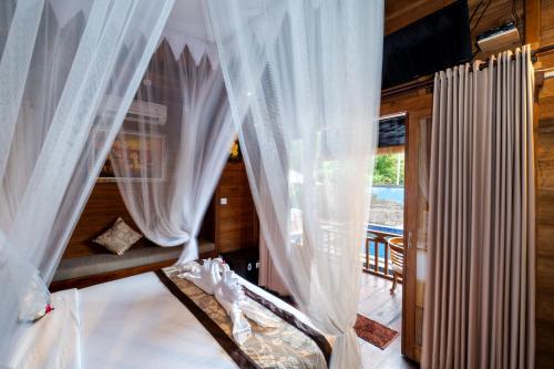 倫邦岸島的住宿－藍夢島光輝日落別墅度假村，一间带白色窗帘的卧室和一个阳台