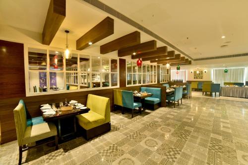 a restaurant with tables and chairs in a room at M Inn in Coimbatore