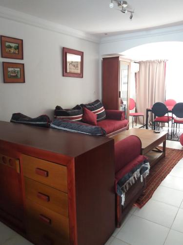 ein Wohnzimmer mit Sofa und Tisch in der Unterkunft studio cosy au lac 1 en face du Movenpick Hotel in Berges Du Lac