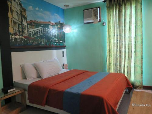 a bedroom with a bed with a painting on the wall at Eurotel Angeles in Angeles