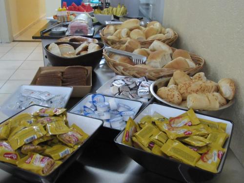 a table topped with trays of different types of food at Hotel Salomão - Próximo a 25 de Março, Bom Retiro, Brás e Rua Santa Efigênia, a 2 minutos do Mirante Sampa Sky e pista de Skate Anhangabaú in Sao Paulo