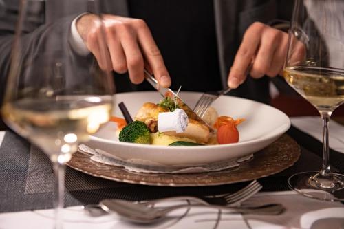 a person sitting at a table with a plate of food at Schlosshotel Rosenau Superior in Schloss Rosenau