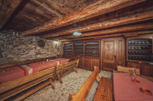 a wine cellar with wooden benches and wine bottles at Apartments "Old house Pajovic" in Virpazar