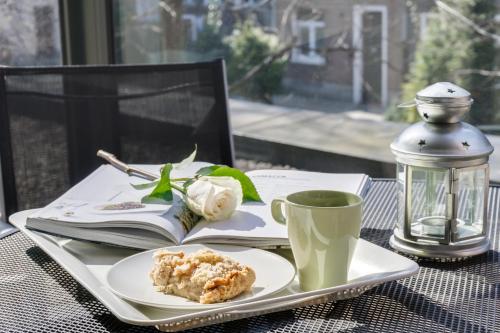 una mesa con un plato de comida y una taza de café en Elite Apartments by the River en Gdansk