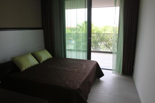 a bedroom with a bed and a large window at Residence Ormeggio in Grado