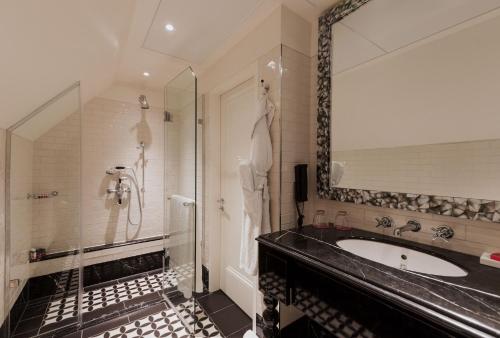a bathroom with a sink and a shower at The LaLit London in London