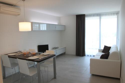 cocina y sala de estar con mesa y sofá en Residence Ormeggio, en Grado
