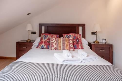 
a bed with a white comforter and pillows at Apartamentos O Almacen in Finisterre
