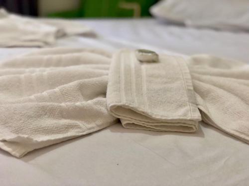 a pile of towels sitting on top of a bed at Hotel Olivier in Três Rios