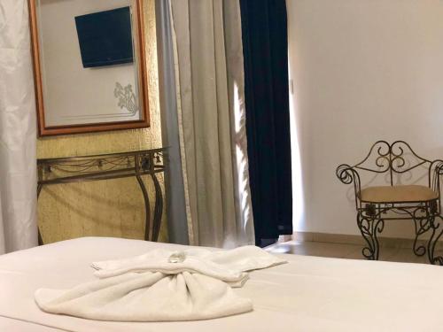 a pair of white towels sitting on top of a bed at Hotel Olivier in Três Rios