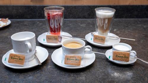 a table with cups and saucers with coffee and drinks at Gasthof Tannen - Alm in Stummerberg