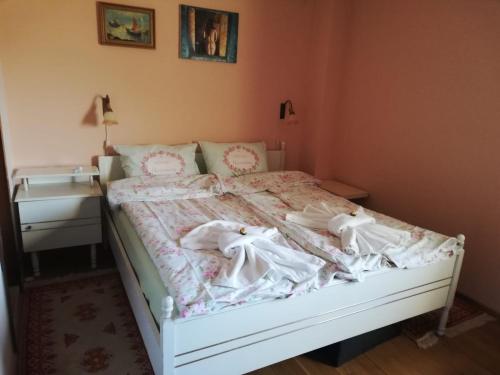 a bedroom with a white bed with a dresser and a bed sidx sidx sidx at Ambrozia Spa and Relax family house in Bachkovo
