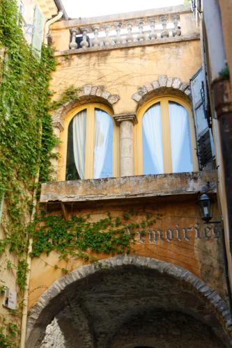 a building with two windows and an archway at Hotel les Armoiries in Valbonne
