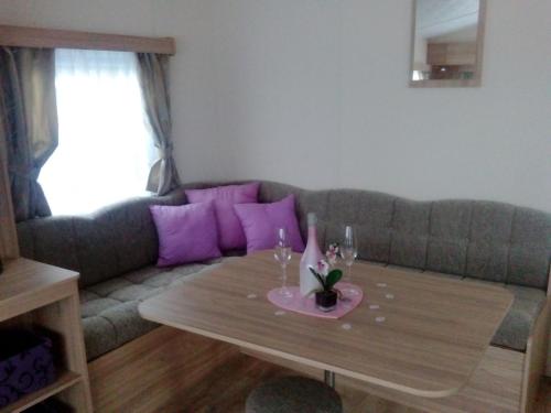 a living room with a couch with a table and purple pillows at Mobilheime in Klaffer am Hochficht