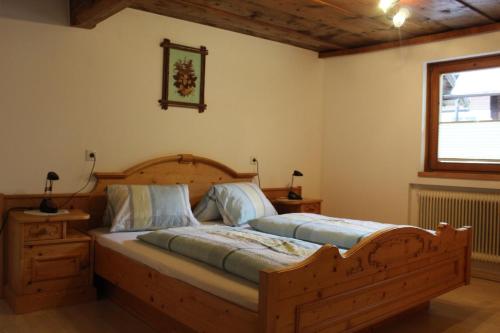 a bedroom with a large wooden bed and a window at Palfner in Rauris