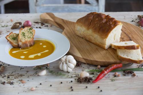 a table with a plate of bread and a bowl of soup at Mayo Resort in Umeanyar