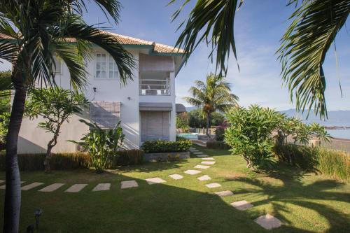 a house with a yard with palm trees at Mayo Resort in Umeanyar