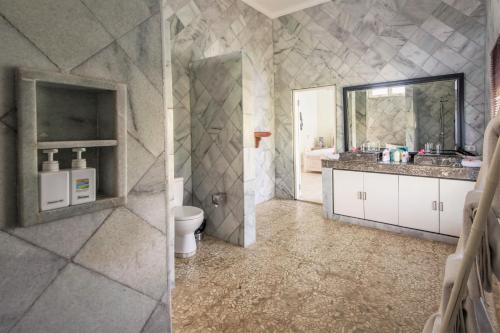 a bathroom with a sink and a toilet and a mirror at Mayo Resort in Umeanyar