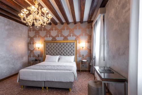 a bedroom with a bed and a chandelier at Palazzo San Lorenzo in Venice