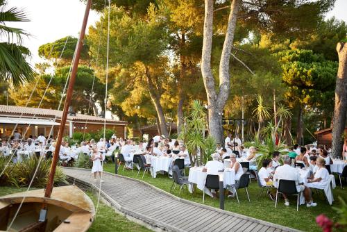 a group of people sitting at tables in a restaurant at Hotel Club Le Plein Sud Vacances Bleues in Hyères