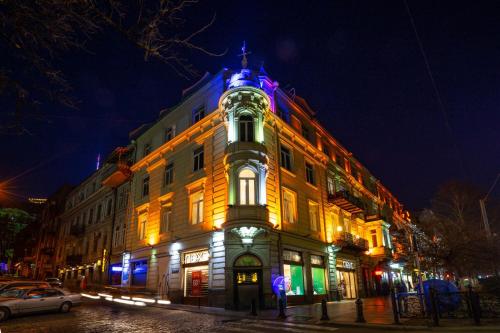 a lit up building on a city street at night at TIFLIS OPERA Aparthotel in Tbilisi City