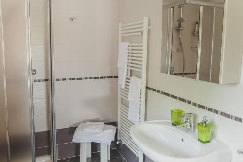 a white bathroom with a sink and a shower at B&B La Tamerice in Valeggio sul Mincio