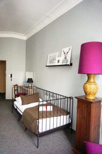 a bedroom with a bed with a pink lamp on a table at Expolis Residence - City Center - 24h POZNAŃ GŁÓWNY #betterthanyourEX in Poznań