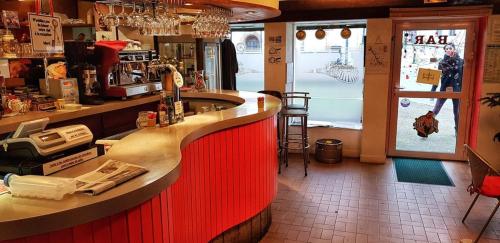 eine Bar in einem Restaurant mit roter Arbeitsplatte in der Unterkunft Hôtel de la Gare in Morlaix