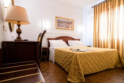 a hotel room with a bed and a lamp at Grand Hotel Italia in Orvieto