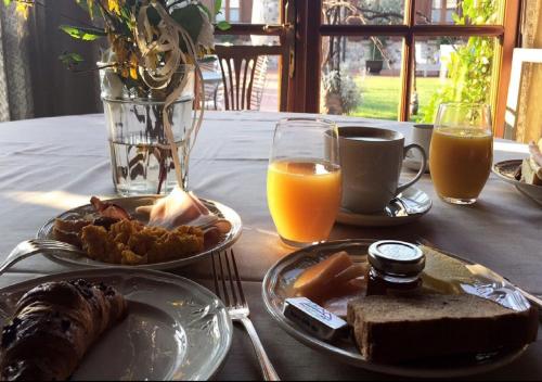 een tafel met twee borden eten en twee glazen sinaasappelsap bij Relaisfranciacorta in Corte Franca