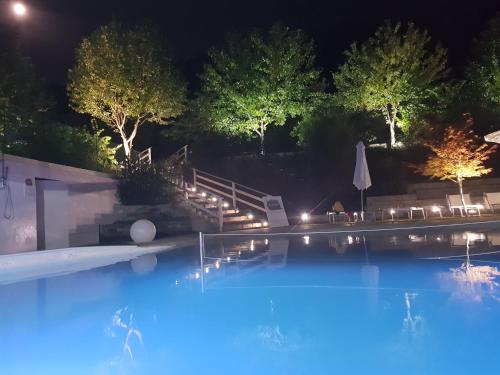 a swimming pool at night with lights at Country house "L'isola che non c'è" in Ancona