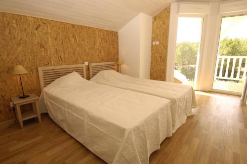 a bedroom with a bed and a large window at Lagrange Vacances - Eden Club in Lacanau-Océan