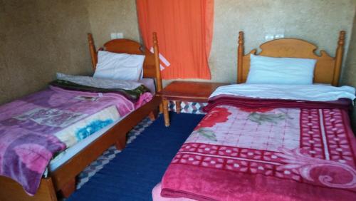 two beds sitting next to each other in a room at gîte les jardins in Goulmima