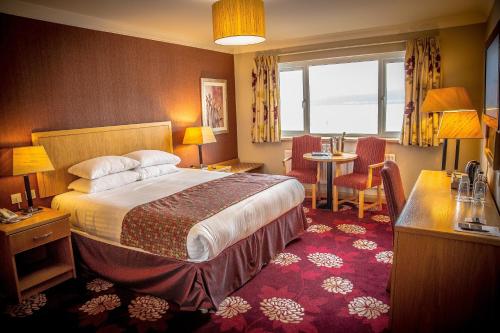 a hotel room with a bed and a table and chairs at Curran Court Hotel in Larne