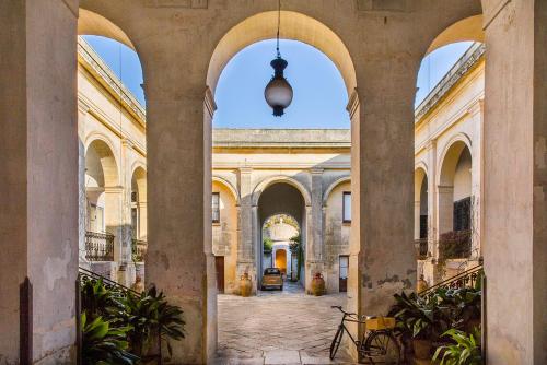 un pasillo vacío en un edificio antiguo con arcos en Palazzo Daniele en Gagliano del Capo