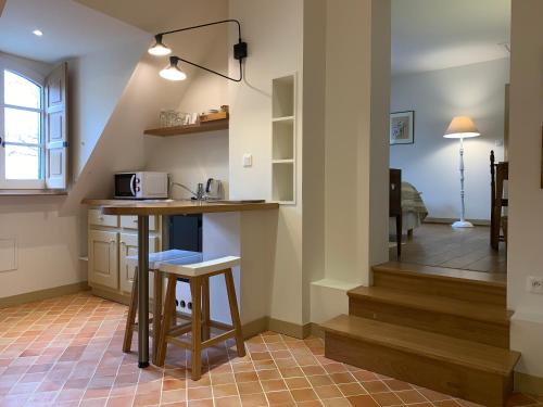 a kitchen with a counter and a stool in a room at Le Domaine de Belleville in Dragey