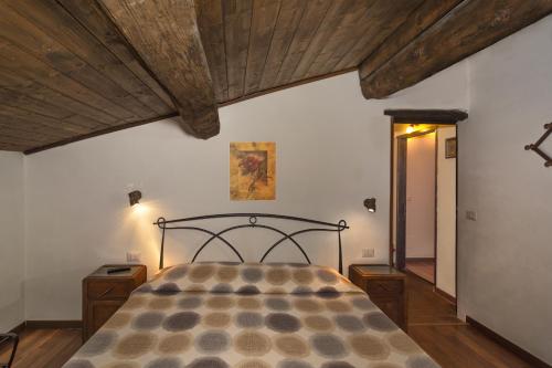 Bed & Breakfast Lucca Fora في كابانّوري: غرفة نوم بسرير في غرفة بسقوف خشبية