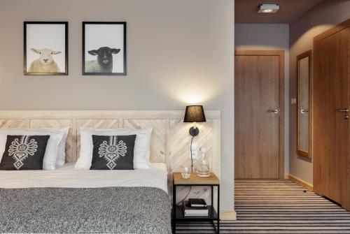 a bedroom with a bed with two animals on the wall at Hotel Foluszowy Potok in Zakopane