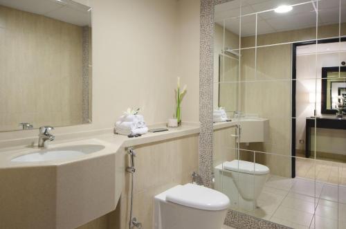 a bathroom with a sink and a toilet and a shower at The Apartments, Dubai World Trade Centre Hotel Apartments in Dubai