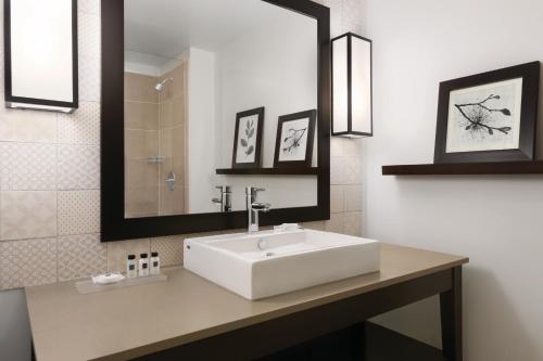 a bathroom with a white sink and a mirror at Country Inn & Suites by Radisson, Belleville, ON in Belleville
