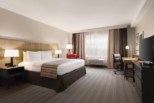 a hotel room with a bed and a desk at Country Inn & Suites by Radisson, Belleville, ON in Belleville