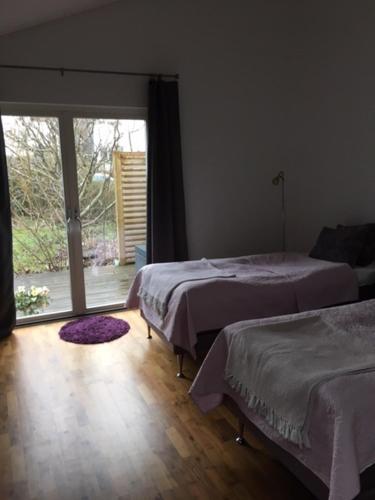 a bedroom with two beds and a large window at The Garden House in Lund